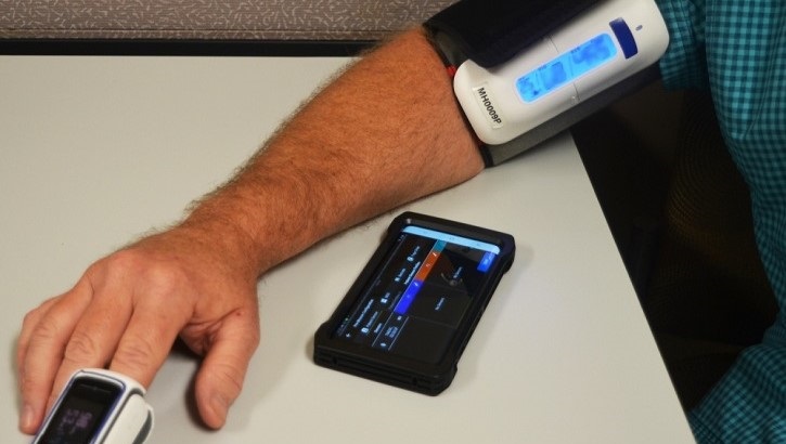 Image of Man's arm with blood pressure cuff and fingertip pulse oximeter. Click to open a larger version of the image.