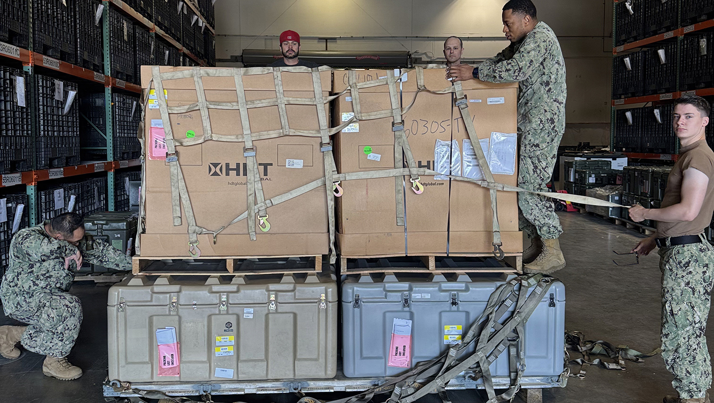 Preparing the Forward Deployable Preventive Medicine Unit (FDPMU) for shipment, members of the Expeditionary Medical Logistics directorate securely stow it prior to transport.