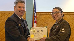 Capt. James Corbett, commanding officer of Naval Medical Leader and Professional Development Command, presents a certificate of completion to U.S. Army Pfc. Rayohnalee Rodriguez during the graduation ceremony