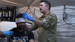 Medical Military Personnel wrapping the head of a patient