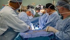 Then-Navy Cmdr. (Dr.) Matthew Bradley (back, left) performs an umbilical hernia operation aboard the hospital ship USNS Comfort