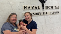 Lt. Danielle Acosta, her mother Tina Cox, and Dahlia, the newest addition to the family, at the very place where their generational story began