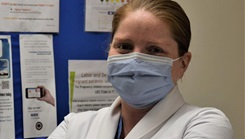 A  female doctor poses for a photo.