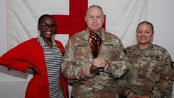  Erica Smith (left), American Red Cross Service to the Armed Forces Regional Program Specialist, presents Col. Ralf Beilhardt (center), commander of the Dental Health Activity – Fort Drum, and Master Sgt. Linda L. Gonzales-Muriel, DENTAC’s senior enlisted leader with the American Red Cross