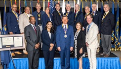 Dr. Craig Shriver, center front, is joined by past Carol Johns Medal recipients (back row) and USU leaders after receiving the 2025 award