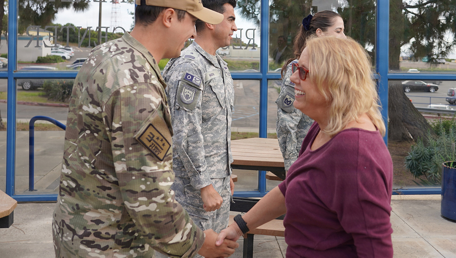 Dr. Lynn Kam shakes hands with Chilean Naval Officers after their tour of the Warfighter Performance research labs. 