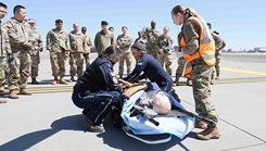 Air Force 60th Operational Medical Readiness Squadron medical personnel report on a notional patient to the Reach 32 Air Medical Services team just before air transport to a local hospital for care