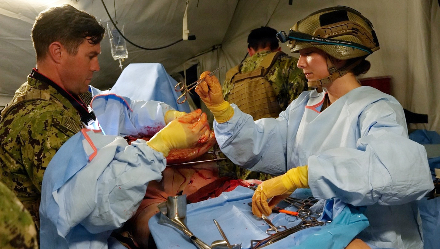 Cmdr. Ryan Schutt (left), surgeon, and Hospital Corpsman 2nd Class Ella Semerad (right), surgical technologist, assigned to Expeditionary Resuscitative Surgical System (ERSS) 12, Navy Medicine Readiness and Training Command Camp Lejeune, North Carolina, conduct a surgical procedure on a simulated casualty during ERSS training 