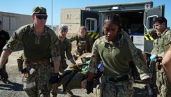 Hospital Corpsman 2nd Class Nya Jobs (right), respiratory therapist, Lt. j.g. Mark Gregg (left), trauma nurse, Capt. David Samaha (middle), general surgeon, and Lt. j.g. Melissa Sullivant (back), trauma nurse, all assigned to Navy Medicine Readiness and Training Command (NMRTC) Jacksonville, transport a casualty from an ambulance into their mission support site during an Expeditionary Resuscitative Surgical System (ERSS) course