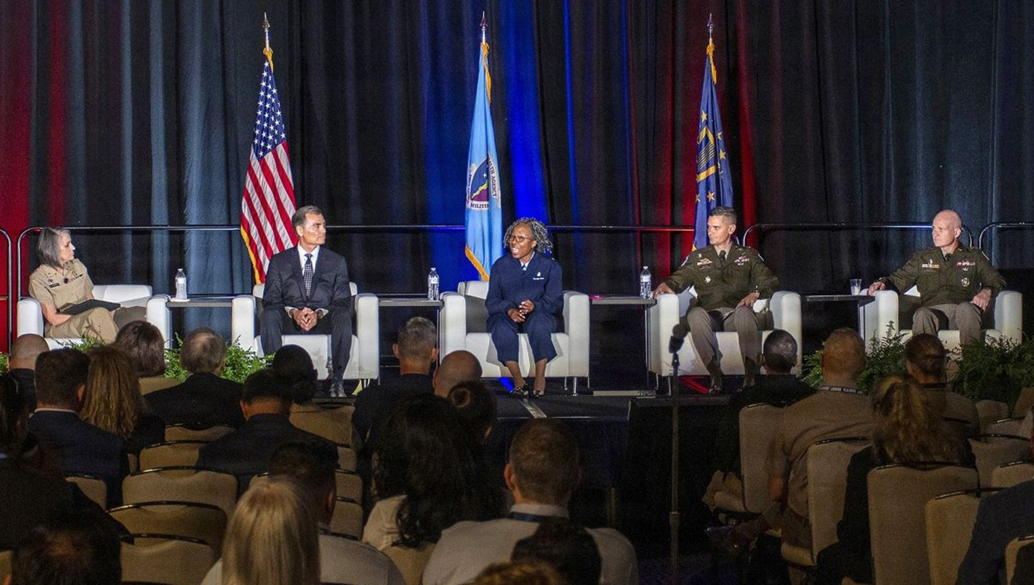 Military personnel on stage during a panel discussion