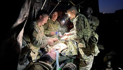 Soldiers with the 82nd Airborne Division treat a simulated casualty during a nighttime field training exercise