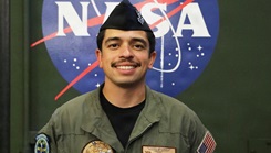 Hospital Corpsman 1st Class Brian Romero posing for a photo in front of the NASA logo