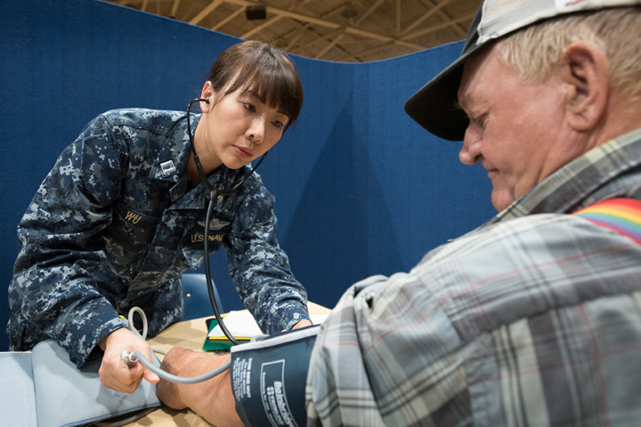Navy Lt. Xin Wu, a nurse from Expeditionary Medical Facility Bethesda in Maryland, checks a patient's blood pressure at a health care clinic set up by the Air Guard and Navy Reserve at a high school in Beattyville, Kentucky. The clinic was part of a mission to train military medical personnel while offering free health care to Eastern Kentucky residents. (U.S. Air Force photo by Lt. Col. Dale Greer)