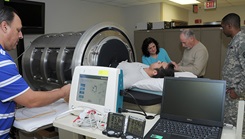 Dr. Victor Convertino, second from right, places monitors on a volunteer in the U.S. Army Institute of Surgical Research lower-body negative pressure chamber. 