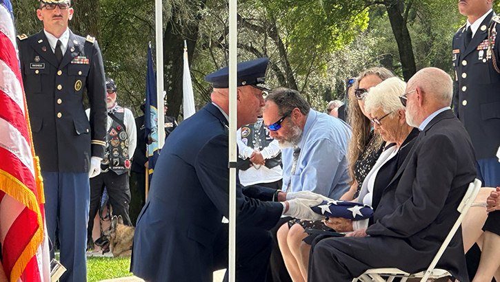 Image of daughter of soldier presented with flag.