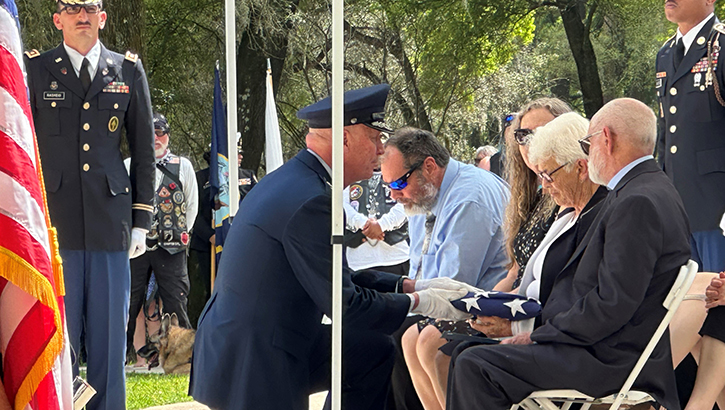 Image of daughter of soldier presented with flag.