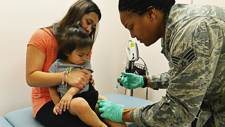 Image of A child receives a vaccine during a visit to the clinic. Click to open a larger version of the image.