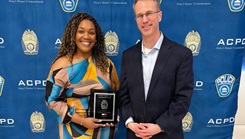 Army Lt. Col. Kevin Kirchgraber, director of Andrew Rader Army Health Clinic, stands with JonNeka Charles-Sein, a licensed practical nurse at the clinic, following her recognition with the Arlington County Police Department