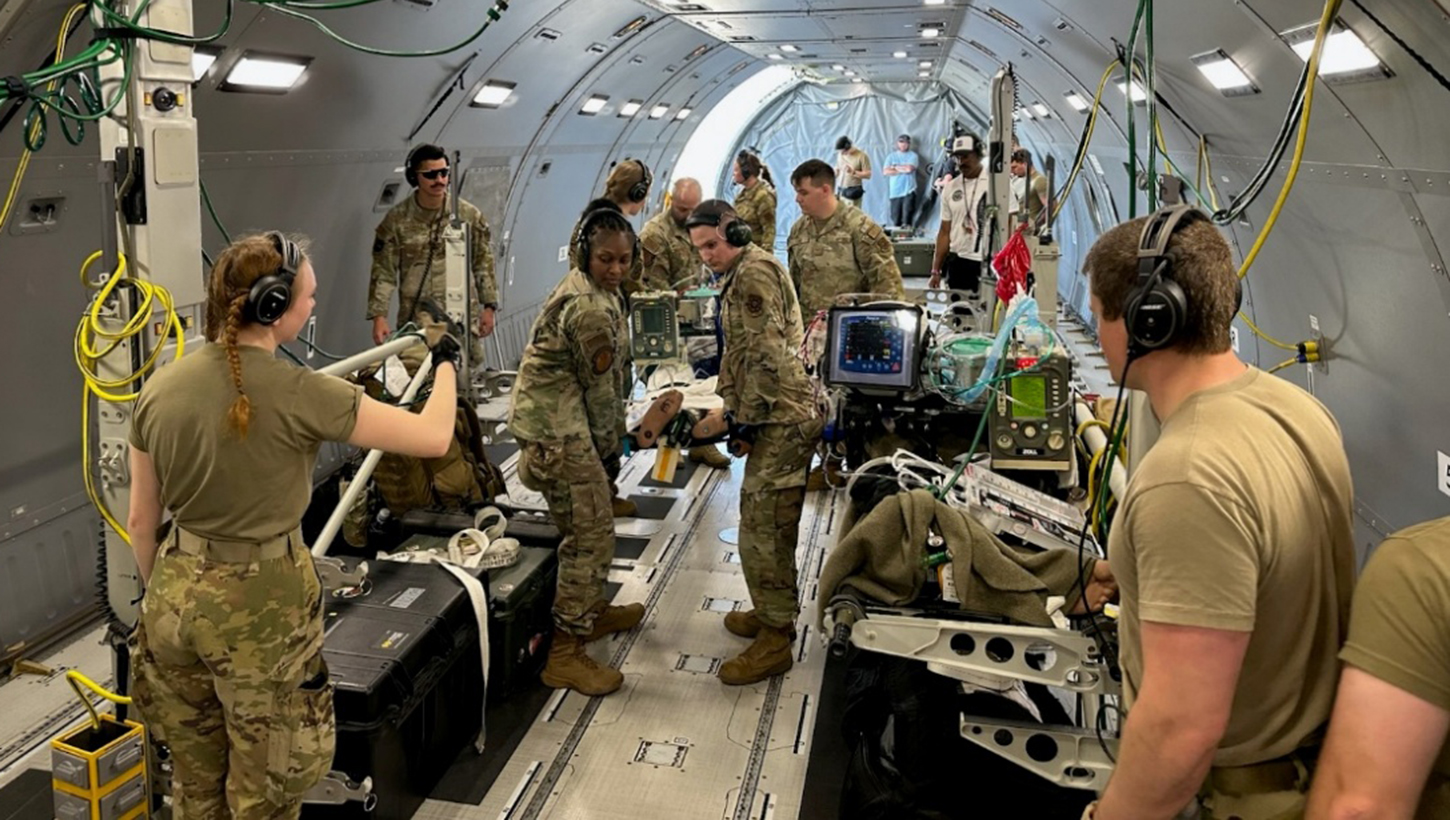 A U.S. Air Force CCATT from BAMC provides simulated medical care to a patient inside a KC-46 Pegasus during a readiness exercise