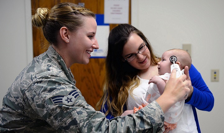 Senior Airman Taylor Scherff, 55th Medical Group Pediatric Clinic medical technician, takes Isabelle Kittel’s temperature as her mom, Casey, holds her Sept. 12, 2017 in the Ehrling Bergquist Clinic, Offutt Air Force Base, Neb. (U.S. Air Force photo by Tech. Sgt. Rachelle Blake)