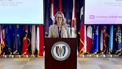 Dr. Jennifer Rusiecki standing at a podium addressing the audience at the second annual Military Environmental Epidemiology Symposium