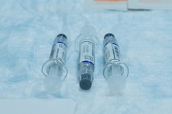 Three influenza vaccine vials are prepared for administration among service members.
