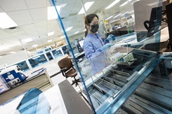 A laboratory scientist organizes vials for processing.