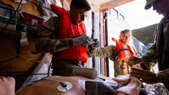 U.S. Army combat medics, assigned to the 8th Forward Resuscitative Surgical Detachment, use the Battlefield Assisted Trauma Distributed Observation Kit - Joint system to document care for a simulated patient during a littoral medical operations exercise