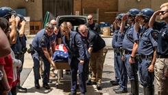 Members of the Harford County (Md.) Sheriff’s Office render honors as Sgt. George “Greg” Dietz’s flag-draped casket is brought into the Uniformed Services University in Bethesda, Maryland