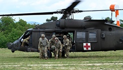 Military personnel exiting a helicopter