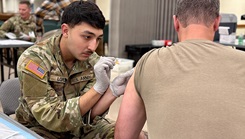 Munson Army Health Center Combat Medic Specialist Pfc. Antonio Lopez administers a seasonal influenza vaccine to a service member at a walk-in community flu-shot event