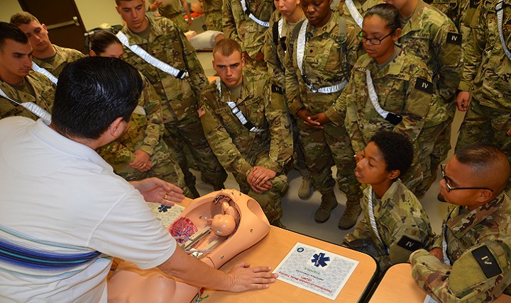 Alonzo Gonzales, a Combat Medic Program emergency medical technician course instructor, lectures students in Alpha Class 70-17 about different obstetrics complications  utilizing a specialized OB training manikin. The OB manikins resemble life-size pelvic cavities inside which the “fetus” can be positioned to replicate any number of complicated situations. (U.S. Army photo by Lisa Braun)