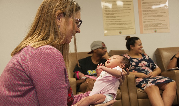 Valerie Miller, nurse midwife, Department of Women’s Health Services, William Beaumont Army Medical Center, holds a newborn baby while she conducts a group prenatal care session with parents of newborns to discuss concerns, expectations and answer any questions the couples may have regarding their birthing experience. (U.S. Army photo by Marcy Sanchez)