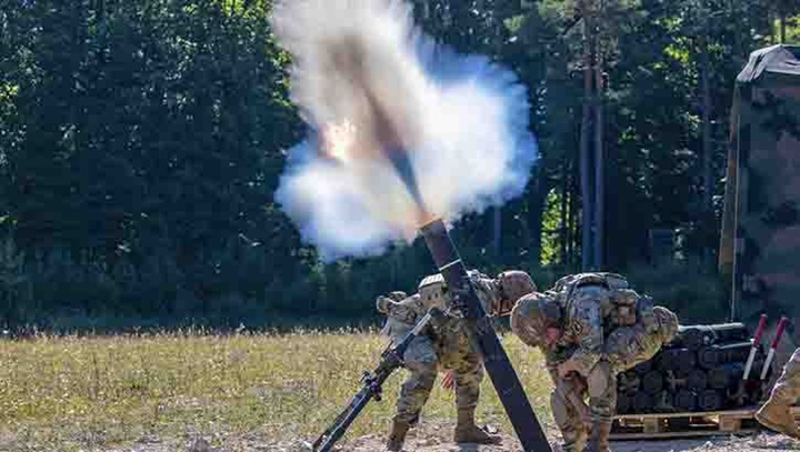 U.S. Army Spcs. Alejandro Ramirez, left, and Michael Hatzioannou fire mortar rounds during the U.S. Army Europe and Africa Best Squad Competition at Grafenwoehr Training Area, Germany, Aug. 10, 2022. The DOD and NATO are studying the effects of overblast pressure and its impact on brain health and held a recent working group conference at Defense Health headquarters in November. (U.S. Army Sgt. Christian Dela Cruz)