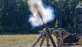 Military personnel fire mortar rounds
