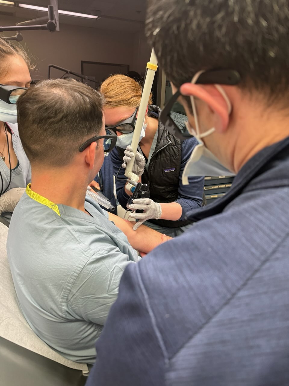 A Dermatology resident participates in a faculty-led teaching opportunity with laser equipment