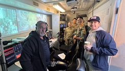 (Center Left to right) Air Force 2nd Lt. Taryin Cates-Beier, Army 2nd Lt. Michael Kim, and Navy Ensign Robert Lee pause inside the control room during a visit to the Navy’s Undersea Rescue Command in San Diego