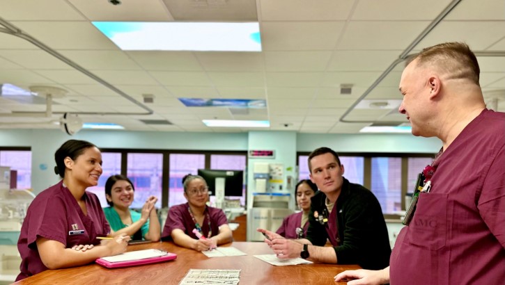 A neonatologist conducts multi-disciplinary rounds in the NICU with team members including the resident, nurse, and respiratory therapist. 