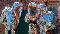 Military personnel wearing radiation suits