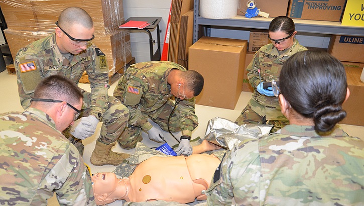 A team of combat medic trainees attend to a "patient" in the EMT warehouse lab.  Students engage in various scenarios in the newly designed EMT simulation labs that resemble real environments that expose students to lifelike patient encounters. (U.S. Army photo by Lisa Braun)