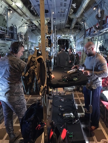 Dr. David Burch (right), a research biomedical engineer and the medical technology solutions team lead for En Route Care Medical Technology Solutions Research Group with the 711th Human Performance Wing at Wright-Patterson Air Force Base, Ohio, collects data on vibration profiles while flying aboard a C-130J Super Hercules. (Courtesy photo)