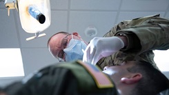 Air Force Lt. Col. Rory Fredrick, a dentist with the 134th Medical Group, Tennessee Air National Guard, performs a routine exam on a member 
