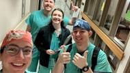 A group of smiling Otolaryngology residents pose in a hallway. 