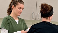 1st Lt. Quinne Johnson, an occupational therapist at Bayne-Jones Army Community Hospital, applies neuromuscular electrical stimulation to Beatrice Hurey during a therapy session
