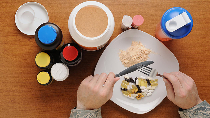 Image of a plate of food with dietary supplements next to it.