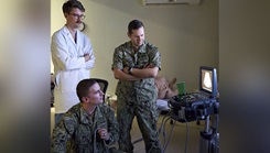 U.S. Navy Lt. Henry Debell, orthopedic surgeon, observes U.S. Navy Lt. Cmdr. Andrew Bessolo, while he practices an assessment with a sonography in trauma exam under the direction of U.S. Navy Cmdr. Radhames E. Lizardo