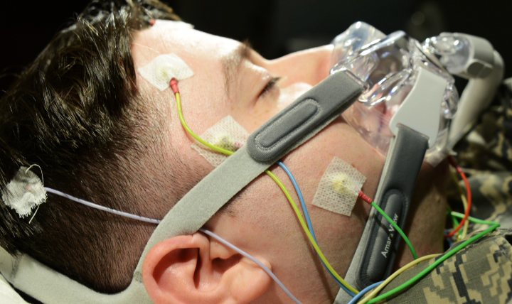 An Airman is hooked up to wires and a continuous positive air pressure mask in the 673d Medical Group Sleep Disorder Clinic at the Joint Base Elmendorf-Richardson Hospital, Alaska. The equipment monitors a patient's brain function, heart rate, temperature, breath, and movement. (U.S. Air Force photo by Airman 1st Class Christopher R. Morales)