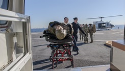 U.S. Navy members assigned to the Naval Hospital Yokosuka push a simulated patient during casualty evacuation training
