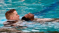 Spc. Jordan Bowman assists a fellow Soldier during combat water survival training at the SFC Guess 50-Meter Pool