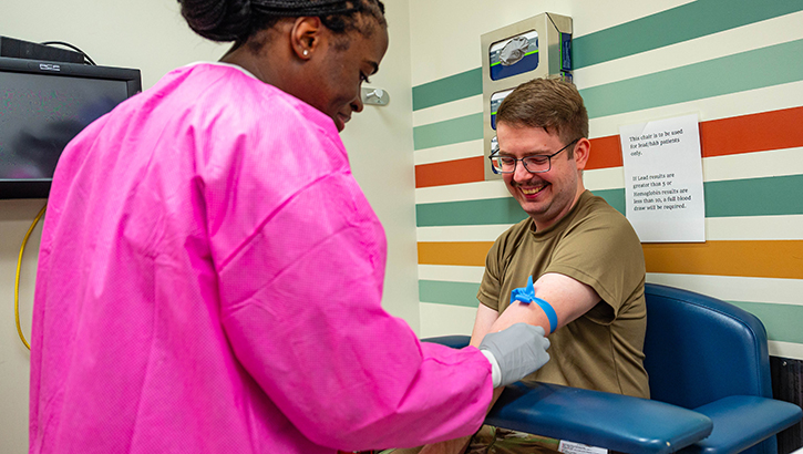 U.S. Air Force Senior Airman Evalyn McBryde (left), 56th Medical Support Squadron medical lab technician, prepares a patient for a blood draw
